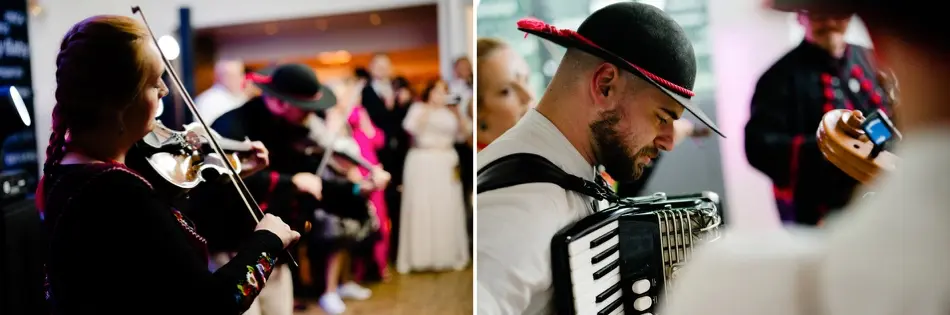 Muzycy kapeli góralskiej w kapeluszach z piórem grają na skrzypcach i akordeonie wśród gości