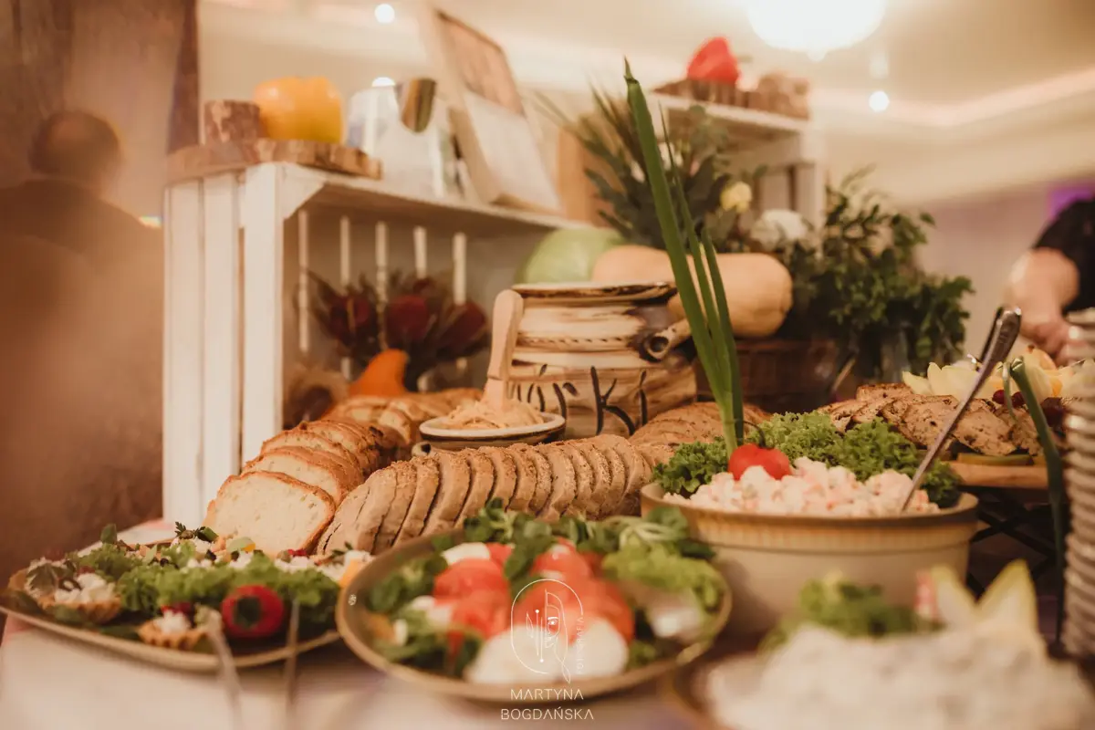 Wiejski stół weselny: pieczywo, smalec w glinianym garnku, sałatki i świeże warzywa