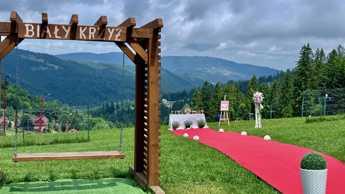 Plenerowe miejsce ceremonii Biały Krzyż: czerwony dywan, drewniana huśtawka i panorama Beskidów